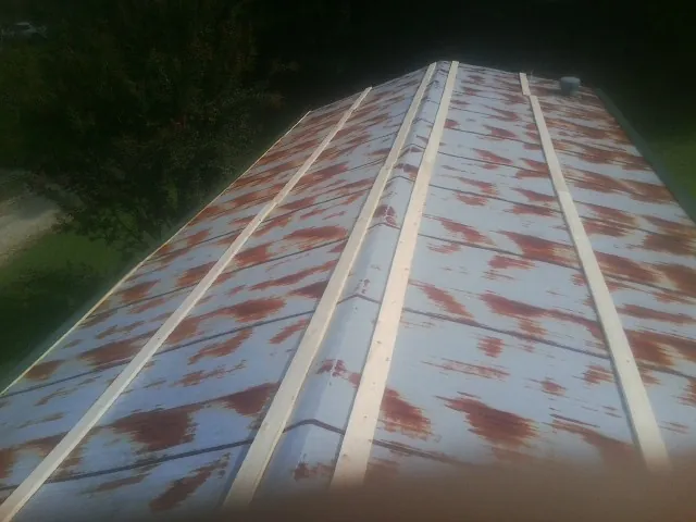 Rusted metal roof panels with new wood purlins before replacement — Storm Damage Roof Repair in Cologne by Roofing Brothers