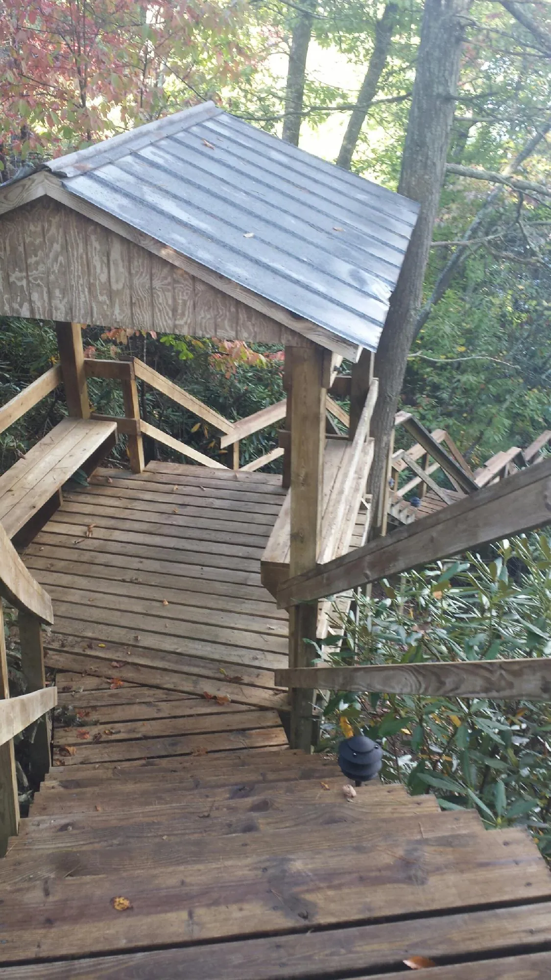 Metal roofed shelter over wooden steps on a wooded walkway — Skylight Repair & Installation work by our crew in Cologne